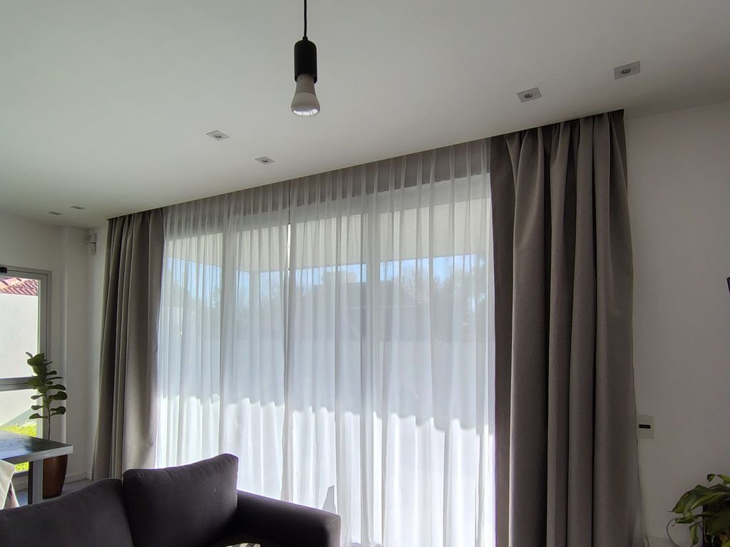 Cortinado textil con blackout y voile en el living de una casa