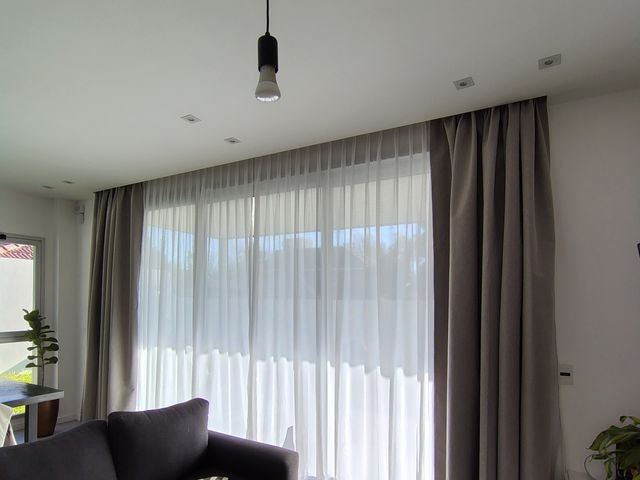 Cortinado textil con blackout y voile en el living de una casa