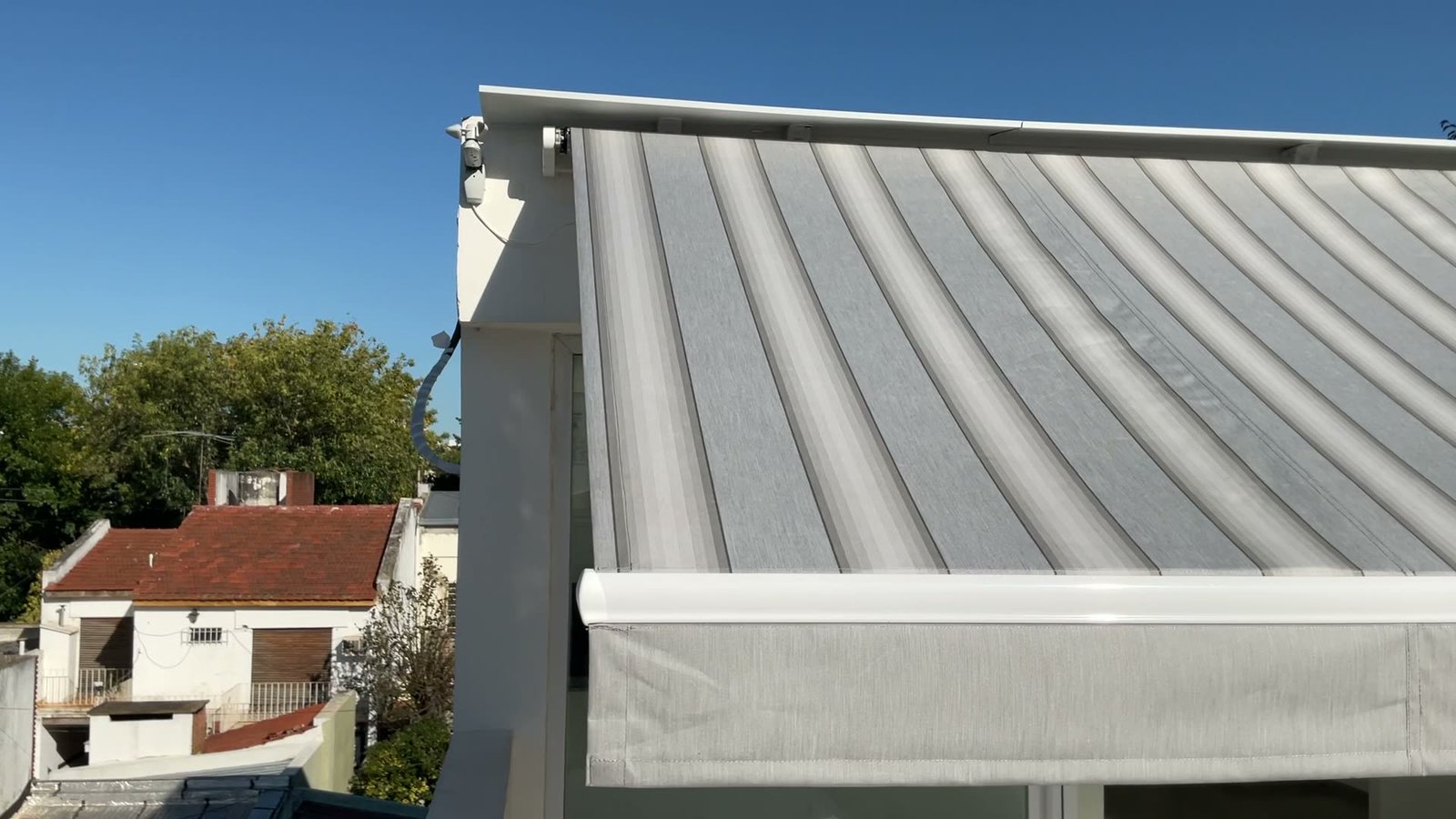 Toldo con brazo invisible desplegado sobre una terraza en City Bell