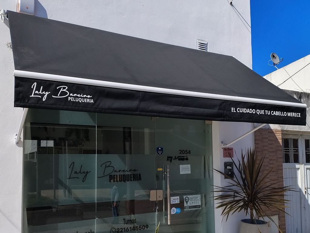 Toldo punto recto negro colocado en el frente de un local comercial